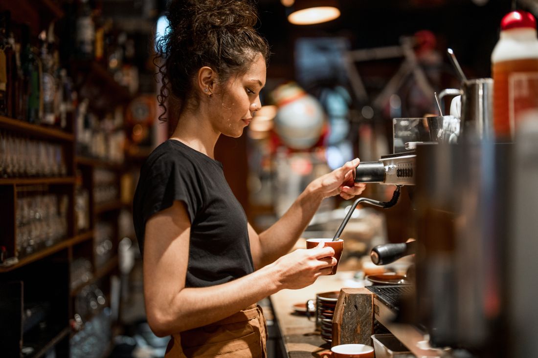 Cafe owner making coffee at the espresso machine