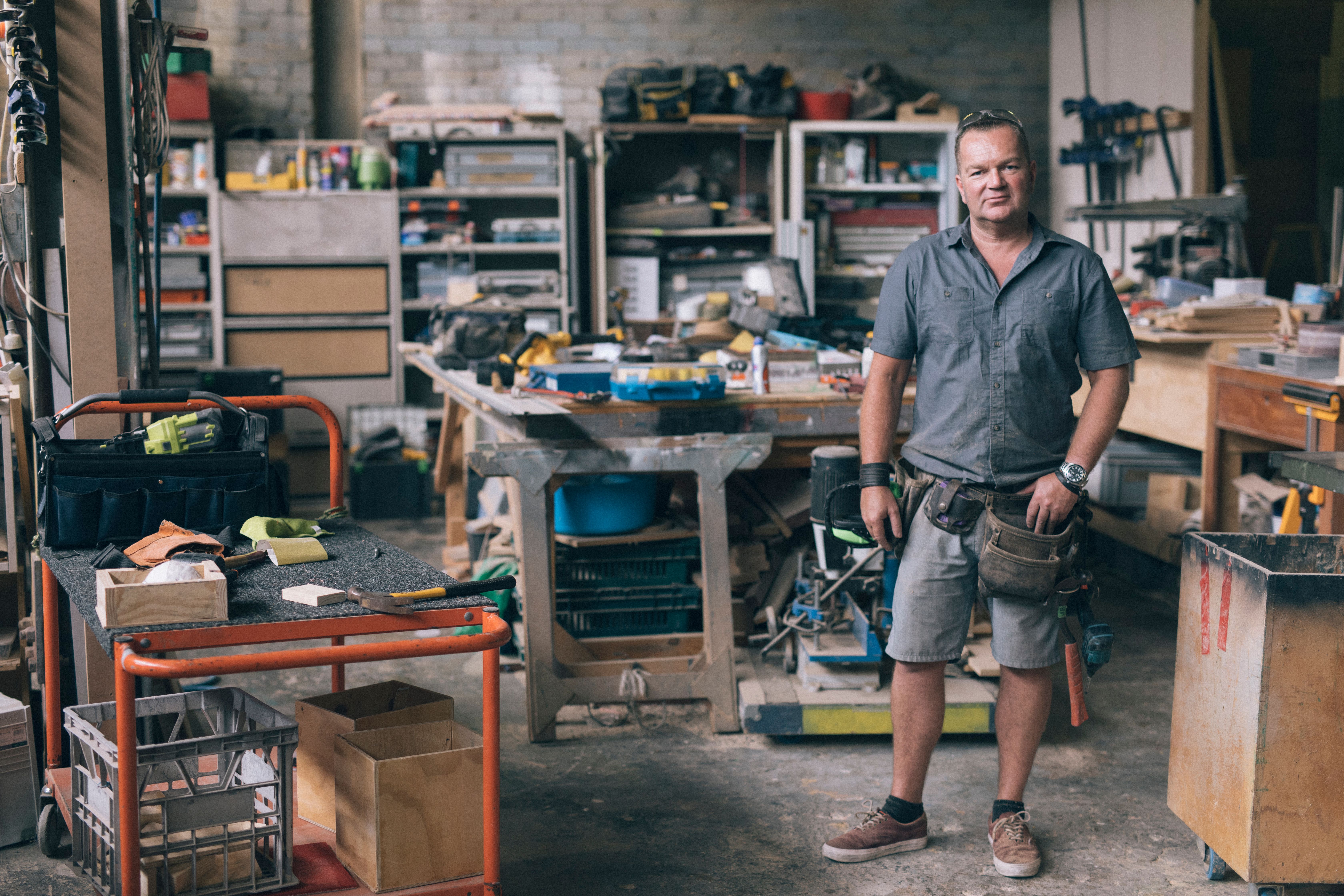 Carpenter standing in a workshop full of tools